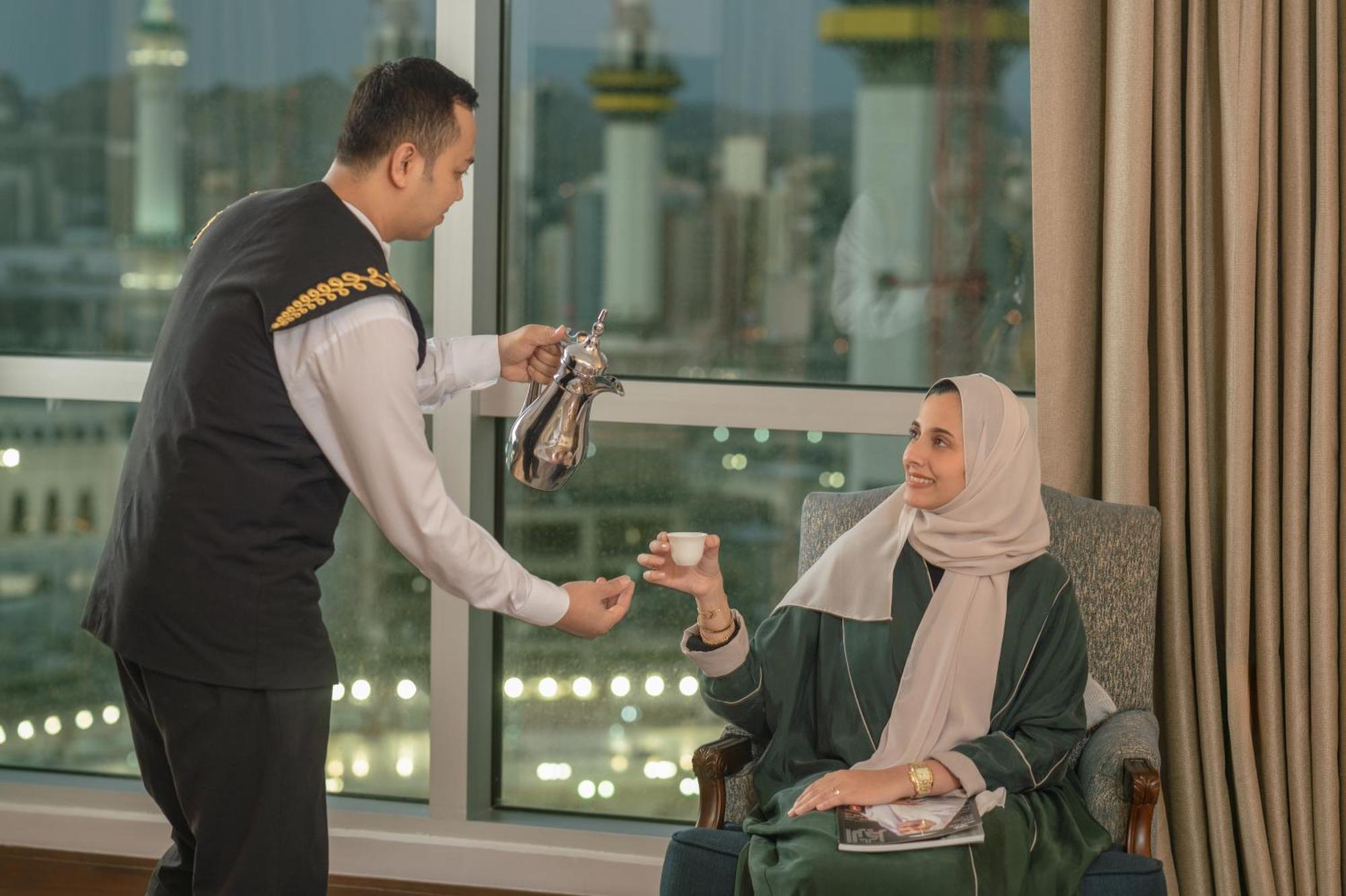 Raffles Makkah Palace Mekka Buitenkant foto A Saudi Arabian woman being served coffee